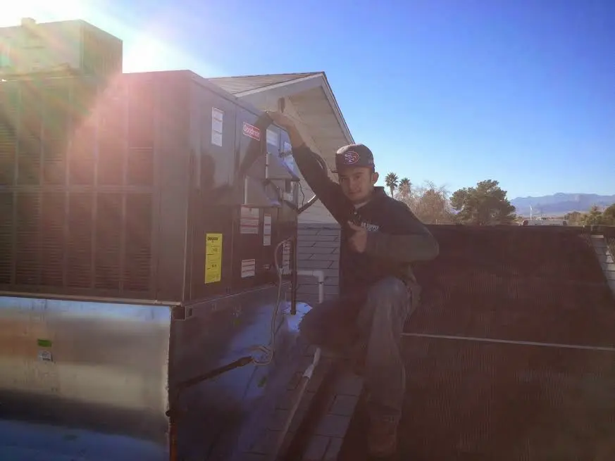 HVAC technician performing Heat Pump Repair on a rooftop unit in Wabash